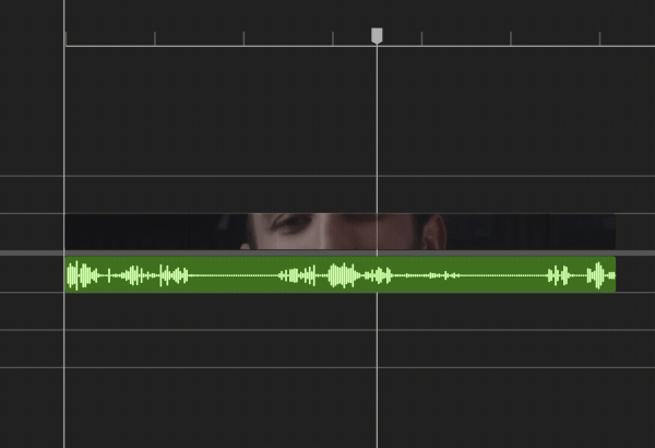 A video editing timeline featuring a green waveform representing a voiceover or dialogue track, synced with a clip showing a partial view of a person's face, with silences being removed automatically.